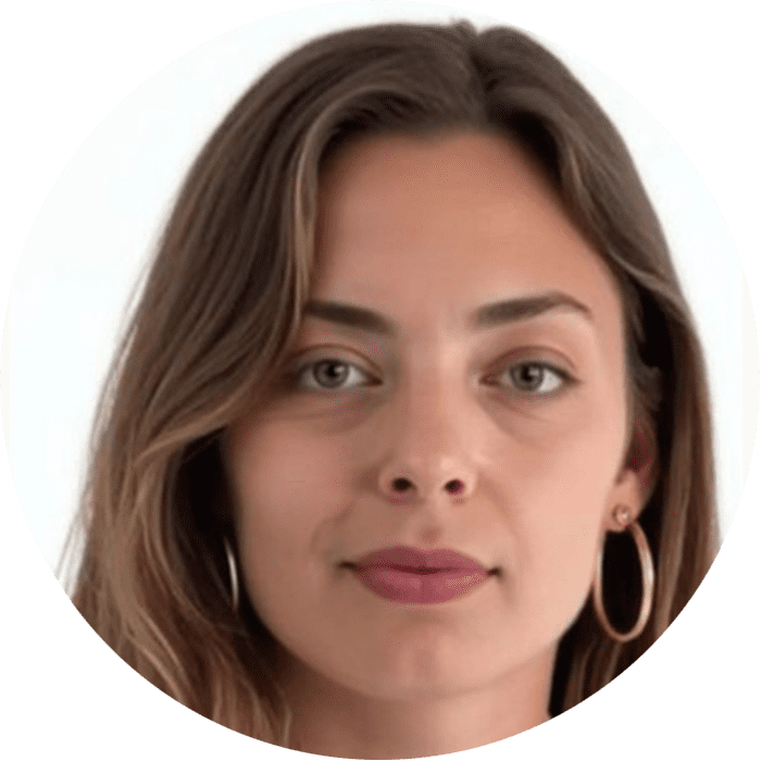 A woman with long brown hair, hoop earrings, and neutral makeup looks directly at the camera against a plain white background—capturing the calm confidence often seen in Brooklyn Therapy sessions with a skilled therapist NYC.