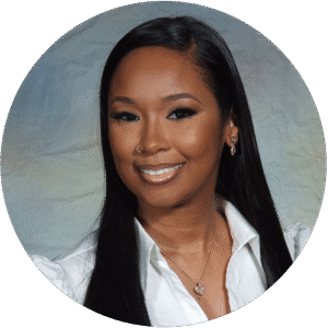 Smiling woman with long straight black hair, wearing a white shirt, necklace, earrings, and a nose ring, posed in front of a light-colored, textured background—an inviting image that reflects the welcoming atmosphere of Brooklyn Therapy for those seeking support from a compassionate therapist in NYC.